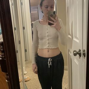 Beige colored crop top with long sleeves.